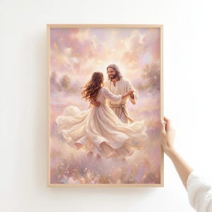 May include: A framed wall art print depicting a long-haired figure in a white robe dancing with a person in a flowing white dress in a soft-toned, ethereal field. The scene features pastel pink and gold clouds in the sky above a meadow.