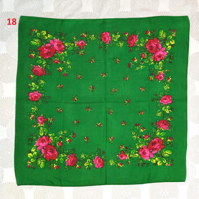 Op de afbeelding: Een vierkante, groene sjaal met een bloemenpatroon. De sjaal heeft grote, rode rozen met groene bladeren en gele accenten langs de randen. Kleine rode bloemclusters zijn verspreid over de groene achtergrond. Het nummer "18" staat in de linkerbovenhoek.