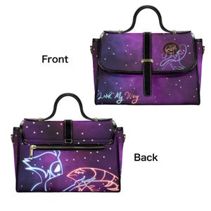 Peut inclure: Sac &agrave; main violet avec un motif galactique et le texte "Look My Way". Le sac a une poign&eacute;e et une bandouli&egrave;re noires, avec une illustration de style n&eacute;on &agrave; l'avant et &agrave; l'arri&egrave;re. Fermeture zipp&eacute;e.