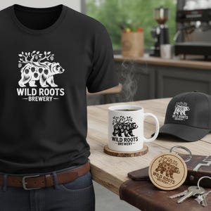 Può includere: Set di merchandising del birrificio "Wild Roots". L'immagine mostra una maglietta nera, una tazza, un cappellino e un portachiavi in legno, tutti con il logo di un orso e la scritta "Brewery".