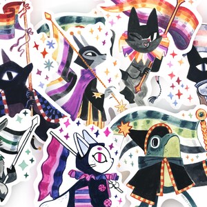 May include: A collection of colorful stickers featuring cartoon animal characters holding flags with various pride flag designs. The stickers have a white border and are decorated with stars. The characters are in various outfits.