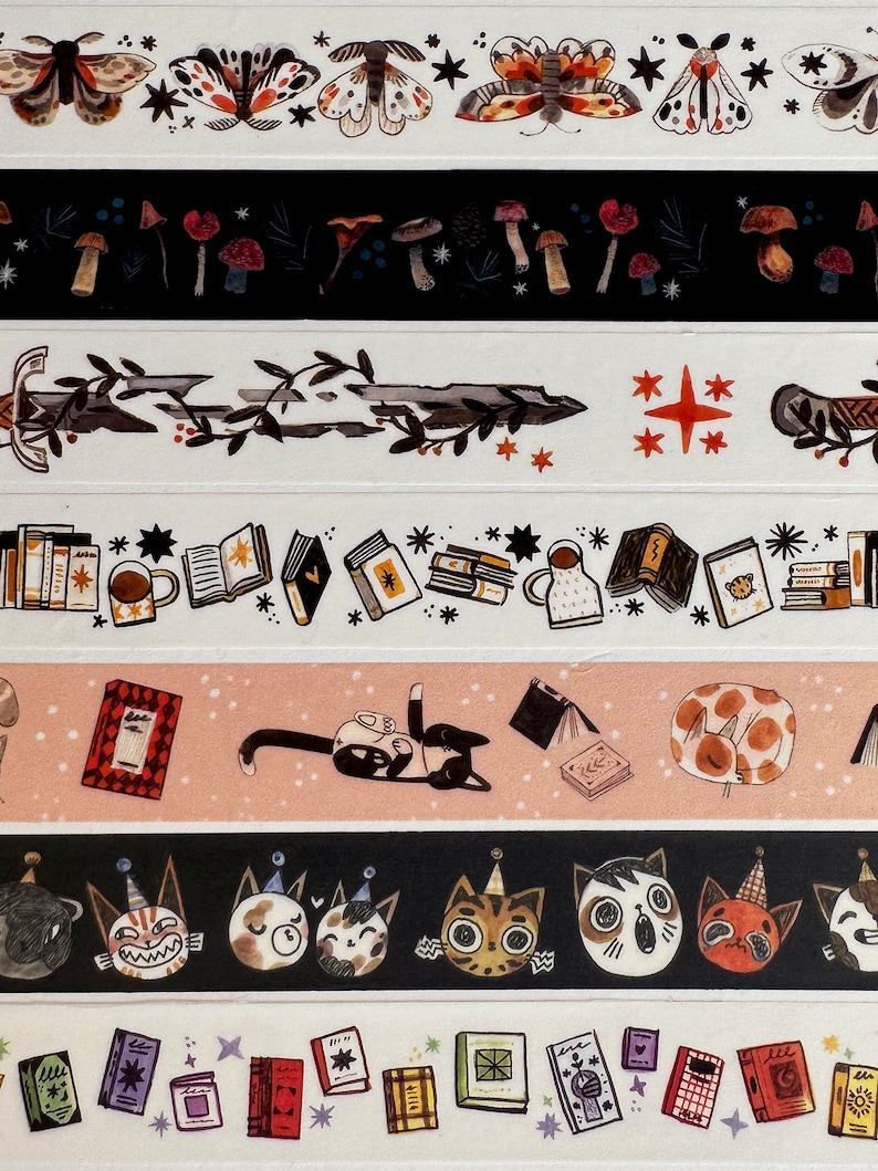 May include: A set of six washi tapes featuring various illustrations, including moths, mushrooms, swords, books, cats, and stars. The tapes are printed on a white background with black and brown accents.