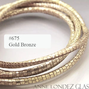 May include: Gold bronze coloured glass cord, twisted into a coil. The cord is textured and has a metallic sheen. The image includes the text #675 Gold Bronze.