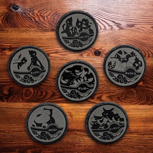 May include: Set of six round slate coasters with engraved Pokémon designs. Each coaster features a different Pokémon character with Japanese text. The coasters are dark gray with a natural stone texture, perfect for any Pokémon fan.
