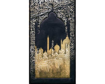 Puede incluir: Una alfombra de oración negra con un diseño de mezquita dorado y plateado. La alfombra presenta una silueta detallada de una mezquita con patrones intrincados y caligrafía. Los bordes están acabados con flecos.