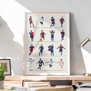 Puede incluir: Una impresión enmarcada que presenta una serie de ilustraciones estilizadas de un jugador de fútbol en varios uniformes y poses. La obra de arte se muestra sobre un fondo claro, con un marco de madera. La impresión está colocada sobre un escritorio de madera.