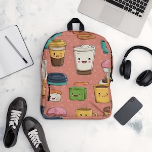 Puede incluir: Una mochila coral con un estampado repetido de simpáticas tazas de café de dibujos animados, sushi y pasteles. La mochila tiene un asa y correas negras. El fondo incluye un portátil, auriculares, un teléfono, un cuaderno y zapatillas negras.
