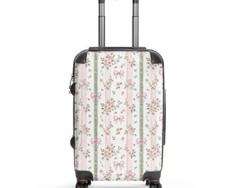 Maleta rígida rosa y verde con lazos y rayas, estilo femenino.