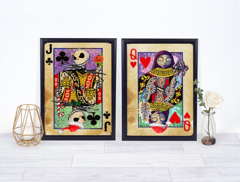 May include: Two framed playing card art prints featuring characters from The Nightmare Before Christmas. One shows Jack Skellington as the Jack of Clubs, the other Sally as the Queen of Hearts. The cards have a vintage, distressed look.