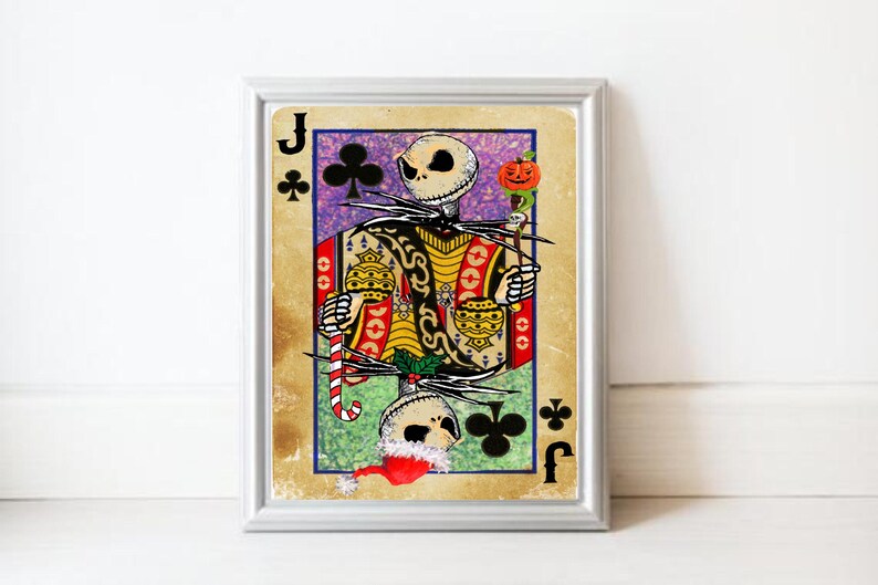 May include: Framed art print featuring a skeletal figure in a playing card design. The Jack of Clubs card has a vintage aesthetic with a colorful design, including a candy cane and pumpkin. The artwork is in a silver frame.
