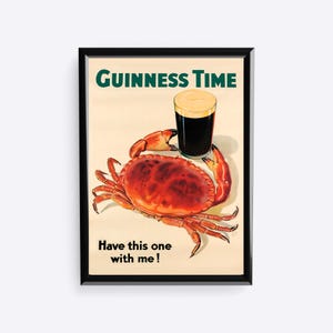 Puede incluir: P&oacute;ster vintage de Guinness Time con un cangrejo rojo y una pinta de cerveza negra. El texto "Guinness Time" y "Have this one with me!" est&aacute; incluido. El p&oacute;ster est&aacute; enmarcado en negro.