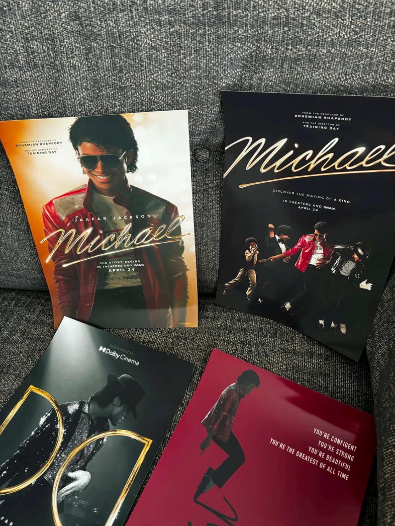 May include: Four promotional posters for the movie "Michael" featuring images of Michael Jackson. The posters have a red, black, and gold color scheme. The text on the posters includes "Michael" and "Discover the Making of a King".