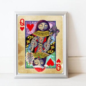 May include: Framed art print featuring a stylized Queen of Hearts card. The artwork depicts a character with pale skin, dark hair, and blue arms, holding a flower and a feather. The card has a vintage, distressed look with red hearts.