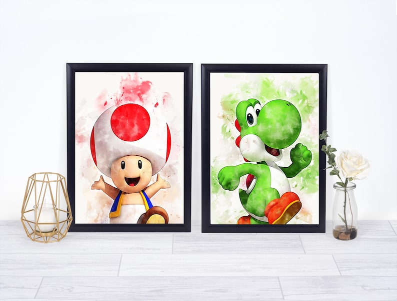 May include: Two framed watercolor prints featuring characters from the Super Mario video game series. One print showcases Toad with a red and white mushroom cap, and the other features Yoshi, a green dinosaur-like character.