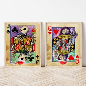 May include: Two framed playing card prints featuring characters from The Nightmare Before Christmas. One shows Jack Skellington as the Jack of Clubs, the other Sally as the Queen of Hearts. The cards have a vintage, distressed look.