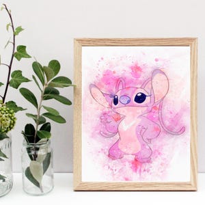 Peut inclure: Une impression encadr&eacute;e &agrave; l'aquarelle repr&eacute;sentant un personnage de dessin anim&eacute; rose avec de grandes oreilles et des yeux bleu fonc&eacute;. L'&oelig;uvre est pos&eacute;e sur un fond rose &agrave; l'aquarelle avec des &eacute;claboussures de couleur. Le cadre est en bois clair.