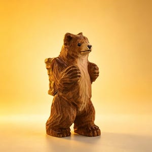 May include: A hand-carved wooden bear figurine with a backpack. The bear is brown with lighter brown accents on its chest and face. The figurine has a detailed, textured surface and stands upright, appearing ready for an adventure.