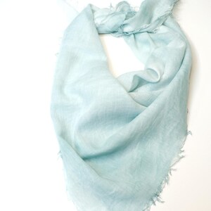 May include: A light blue linen scarf with a frayed edge.