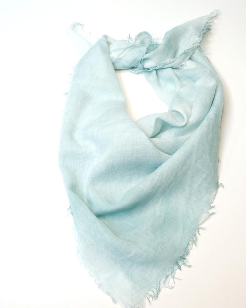 May include: A light blue linen scarf with a frayed edge.