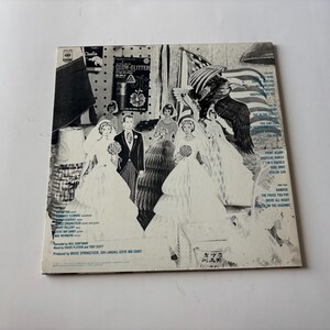 May include: Vintage album cover featuring a collage of images, including a bride and groom, an American flag, and an eagle. The cover is primarily black and white with some blue accents and text.