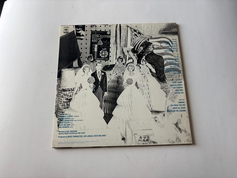 May include: Vintage album cover featuring a collage of images, including a bride and groom, an American flag, and an eagle. The cover is primarily black and white with some blue accents and text.