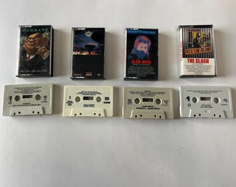 May include: A collection of eight cassette tapes, including Warrant, Aldo Nova, and The Clash. The tapes are white with black text and are arranged in two rows.
