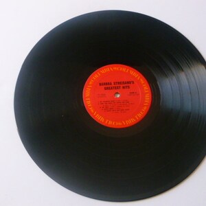 May include: Black vinyl record with a red label that reads "Barbra Streisand's Greatest Hits".