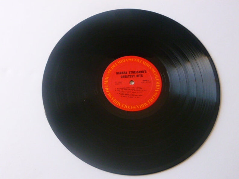May include: Black vinyl record with a red label that reads "Barbra Streisand's Greatest Hits".