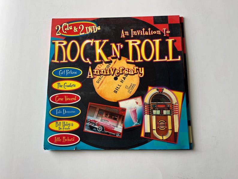 May include: A blue and yellow book cover with the title "Rock 'n' Roll Anniversary" and a picture of a vintage jukebox. The cover also features a record with the names of artists like Carl Perkins, The Coasters, Gene Vincent, and Little Richard.