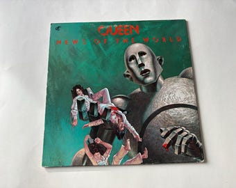May include: Album cover for Queen's "News of the World." The artwork features a giant robot holding people. The album title is in red, with the band's name above it. The background is a teal green color.
