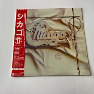 May include: A vintage vinyl record album cover featuring the band Chicago. The cover is a close-up of a brown paper package with the band's name printed in a stylized font. The album is titled "Chicago 17" and is in Japanese.