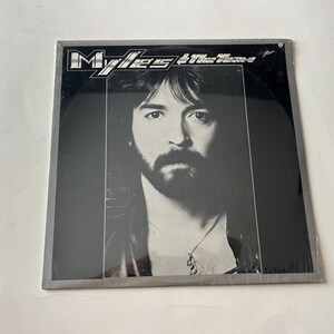 May include: A black and white album cover featuring a man with long hair and a beard. The album title is "Myles & The Masters" in white text.