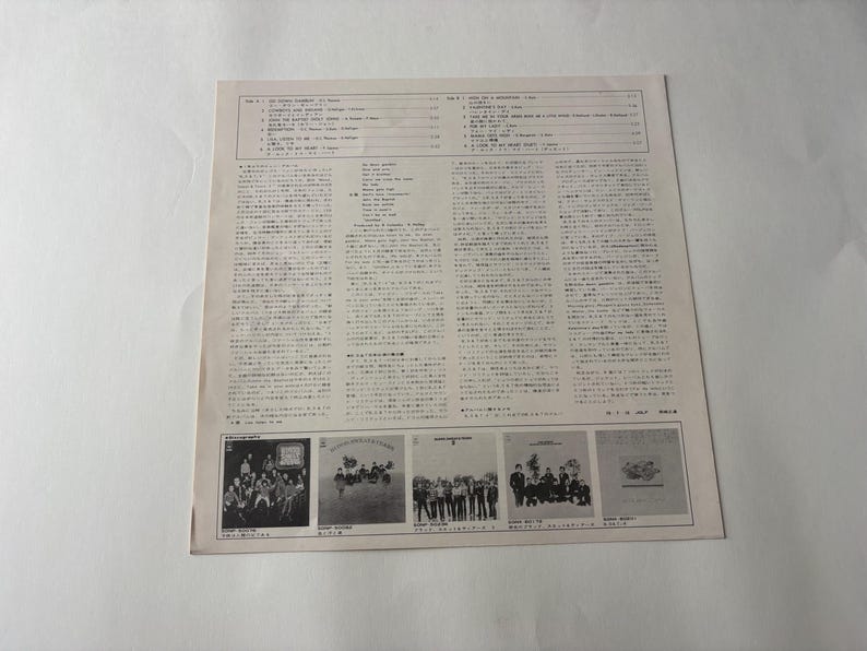 May include: A vintage record album cover with Japanese text and images. The cover features a list of songs and lyrics, along with several small images of the band. The album is on a white background.