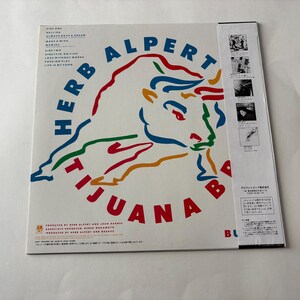 Puede incluir: Una portada del &aacute;lbum de Herb Alpert & The Tijuana Brass. La portada del &aacute;lbum es blanca con las palabras "Herb Alpert Tijuana Brass" en azul y rojo. Un gr&aacute;fico de toro colorido est&aacute; en el centro. El t&iacute;tulo del &aacute;lbum es "Bu".