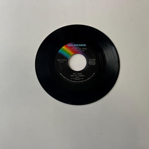 May include: A black vinyl record with a colorful label. The label says "MCA Records" and "The Clock" with the artist "BOZ SCAGGS AND HIS COMETS" and the song title "Limozeen".