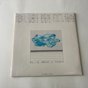 May include: Album cover for "Blood, Sweat & Tears" featuring a blue cloud graphic on a white background. The album title is printed in black, with a grid pattern and horizontal lines. The top has architectural drawings.