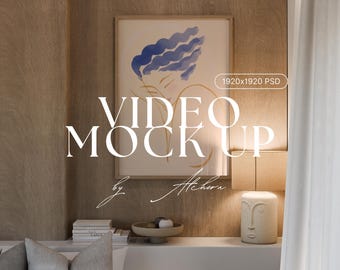 Op de afbeelding: Een ingelijste kunstdruk met blauwe abstracte vormen hangt boven een witte plank. De tekst "VIDEO MOCK UP" wordt prominent weergegeven, met "by Alchera" eronder. Een decoratieve lamp en een kom zijn ook zichtbaar.