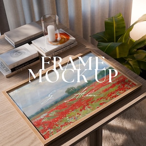 May include: A framed landscape painting depicting a field of red flowers, with the text "FRAME MOCK UP" and "by Alchera". The painting is displayed on a wooden table, with books and a candle in a glass holder.
