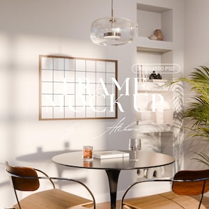 May include: Interior scene with a round black table, two wooden chairs, and a framed grid. A glass pendant light hangs above the table. The text "FRAME MOCK UP" is visible on the wall. A glass of water and a small glass with a red substance are on the table.