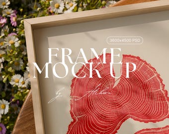 May include: A wooden framed print mockup featuring a red tree ring design. The words "FRAME MOCK UP" are displayed in large, bold letters. The image is set against a soft, neutral background.
