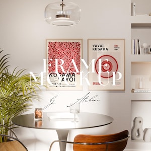May include: Interior design mockup featuring two framed art prints with red and white abstract designs. The prints are mounted on a white wall above a round table with a glass and a chair. A plant and a light fixture are also visible.