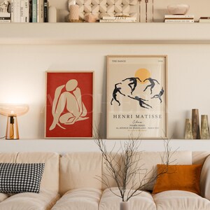 2 Frame Gallery Wall Mockup Living Room with Scandinavian decor featuring wood frame mockup. Includes Henri Matisse poster art displayed in DIN A-series ratio for Photoshop mockup or Photopea PSD use. High-resolution 300 DPI with visible glass reflection. Framed poster mockup ideal for showcasing set of 2 arts or multiple poster mockup in calm, modern interior mockup scene. Perfect for gallery wall art presentation in a cozy, minimal space.