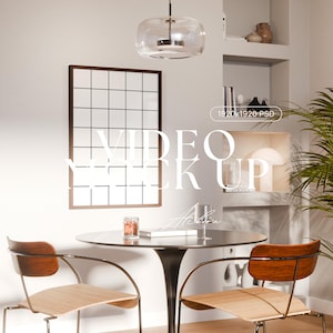 Puede incluir: Una escena interior moderna con una mesa redonda y dos sillas. Una obra de arte enmarcada con forma de cuadrícula cuelga de la pared. Se muestra el texto "VIDEO MOCK UP". Una lámpara colgante de cristal cuelga sobre la mesa.
