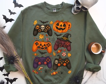 以下が含まれることがあります： ハロウィーンをテーマにしたデザインのグリーンスウェットシャツ。デザインには、カボチャ、コウモリ、魔女の帽子などのハロウィーン要素を備えたゲームコントローラーがいくつか含まれています。お菓子や秋の葉もデザインに含まれています。