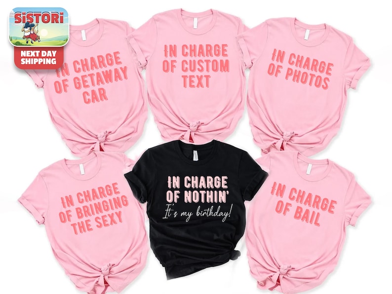 a collection of pink t-shirts with various humorous text printed on them, along with a black t-shirt featuring a different text message.