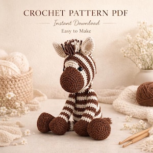 Può includere: Un zebra all'uncinetto a strisce marroni e bianche, seduta. L'immagine include il testo "CROCHET PATTERN PDF, Download istantaneo, Facile da fare". Sono presenti anche gomitoli di lana, uncinetti ed elementi decorativi.