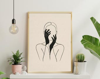 Op de afbeelding: Een ingelijste wandkunstprint met een zwarte lijntekening van een persoon met handen voor het gezicht tegen een lichtbeige achtergrond. Het kunstwerk zit in een eenvoudige lichtgekleurde houten lijst en toont een strakke esthetiek.