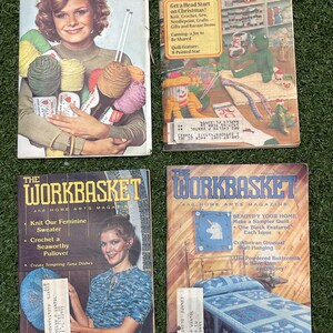May include: Four vintage magazines on a green surface. The magazines feature images of knitting, crochet, and home arts projects. One magazine cover shows a woman holding yarn, while others display craft projects and text like "Learn to Knit" and "The Workbasket".