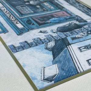 May include: Framed watercolor print of a street scene with a pub. The pub is blue with the name "KERNANS" and the text "Guinness is good for you". The artwork has a blue and white color scheme.