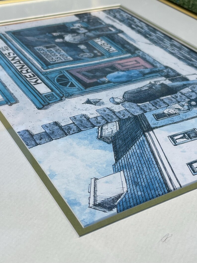 May include: Framed watercolor print of a street scene with a pub. The pub is blue with the name "KERNANS" and the text "Guinness is good for you". The artwork has a blue and white color scheme.